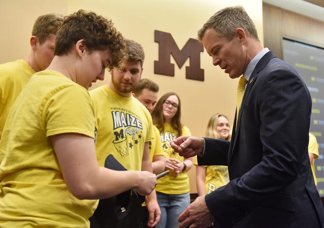 Michigan head basketball coach Dusty May, right, obliges Maize Rage member Emily Vandenbossche, left, of Marine City, on the request to sign a few items for the group after the press conference at the University of Michigan in Ann Arbor, Mich. on Mar. 26, 2024.