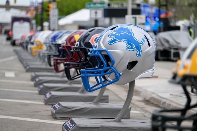 Rows of football helmets line Jefferson Ave. at the NFL Draft experience, at Hart Plaza, in Detroit, April 24, 2024.