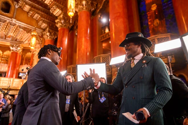 LSU wide receiver Malik Nabers, left, greets Cam Newton before an interview during the NFL Draft red carpet arrival, at the Fox Theatre, in Detroit, April 25, 2024.