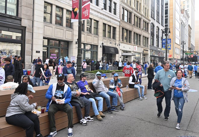 Fans of all teams take a breaks with benches along Woodward Avenue enjoy the 2024 NFL Draft on the streets of Detroit.