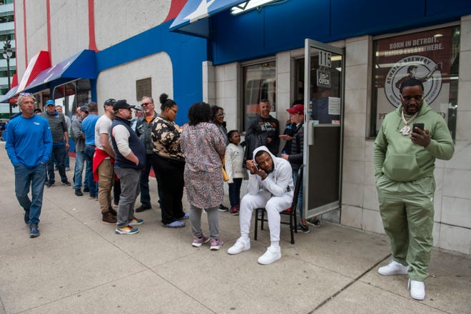 A crowd waits in a long line to order food at American Coney Island as thousands of football fans arrive for the NFL Draft on Friday, April 26, 2024 in downtown Detroit.