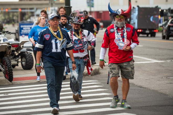 From left, Texas residents Hector Hernandez, "Toucan Dan" and Eddie Hernandez walk through downtown Detroit on their way to the NFL Draft on Friday, April 26, 2024.