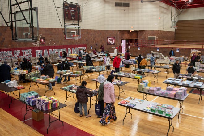 Community members look through a collection of thousands of books during a free book giveaway hosted by the Hamtramck Federation of Teachers and Reading Opens the World on Saturday, April 27, 2024 at the Hamtramck Community Center.
