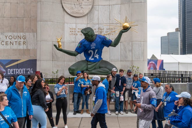 Football fans pose for selfies with the Spirit of Detroit statue during the final day of the 2024 NFL Draft on Saturday, April 27, 2024 in downtown Detroit.