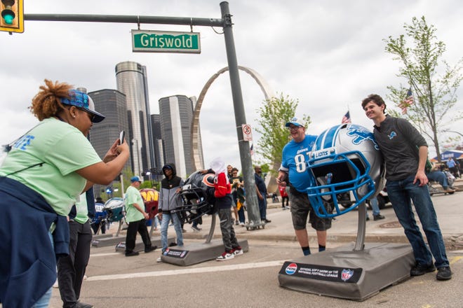 Detroit Lions fans pose for photos with a giant Lions helmet during the final day of the 2024 NFL Draft on Saturday.