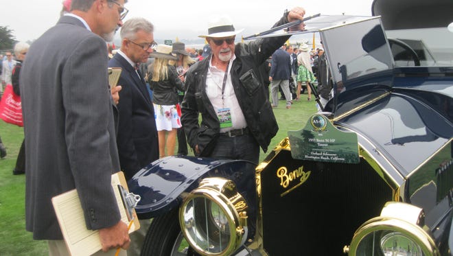 Concours judges examine the engine compartment of the 1911 Benz shown by Gerhard Schnuerer of Huntington, Calif.
