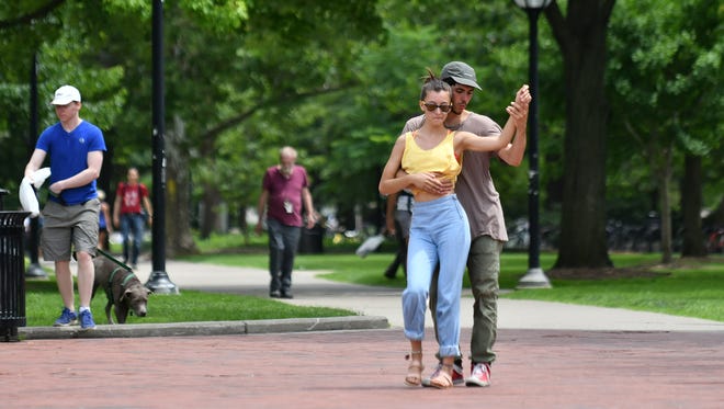 Ava Vincent, 20, and Davis Ransdell, 24, both of Ann Arbor dance to music  playing near the Diag in Ann Arbor on June 22, 2018. The two are trying to get people to move more in general. Davis says, " It is greatly undervalued, the contribution to a person's well being and mental health, that moving brings." They teach social dance classes nearby at Open Floor Studios.