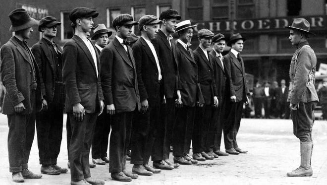 Young recruits stand in formation in front of a military official in Detroit  during World War I.