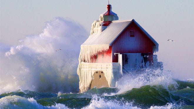 AWARD OF EXCELLENCE: "Frigid," by Jim Swoboda of Kentwood, captures waves crashing around Grand Haven's icy outer lighthouse in December. "That was a crazy windy day," Swoboda said. His photo session ended when "I got swamped by a wave from inside the channel that I never saw roll over the top."