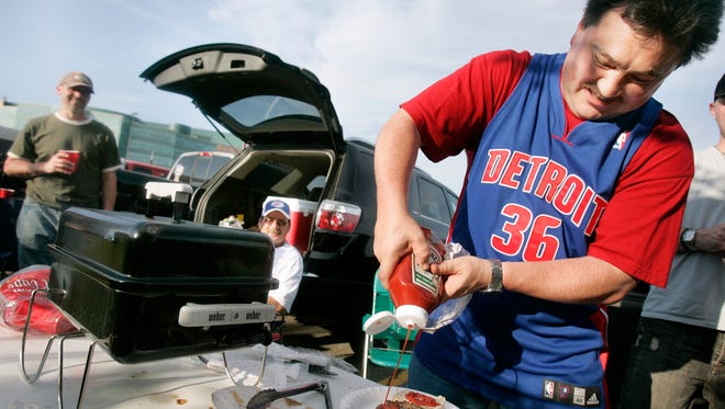 Larry Harden of Auburn Hills puts ketchup on his burger while tailgating with friends outside The Palace on May 26, 2008.