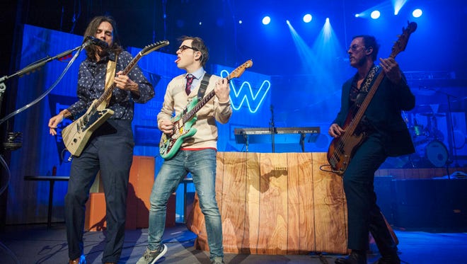 Weezer guitarist Brian Bell  (from left), singer/guitarist Rivers Cuomo and bassist Scott Shriner perform at DTE Energy Music Theater in Clarkston, Michigan on Friday, July 13, 2018. The Pixies shared the bill and played first.