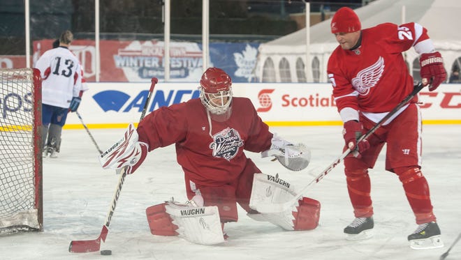 Red Wings alumni Chris Osgood, left, and Darren Mcarty practice together at the rink at Comerica Park in Detroit, December 26, 2013.