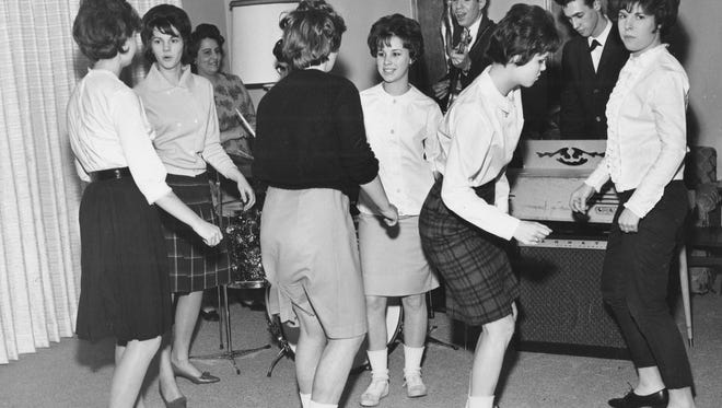 Teenage girls  dance to a band in 1962.