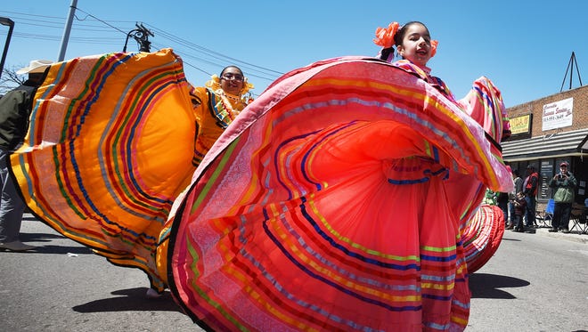 Dancers from Ballet Folklo'rico De Detroit Tracy Gallardo and Alondra Castellaos, 11, spin their way down W. Vernor Hwy. during the Cinco de Mayo parade in Detroit on May 7, 2017.