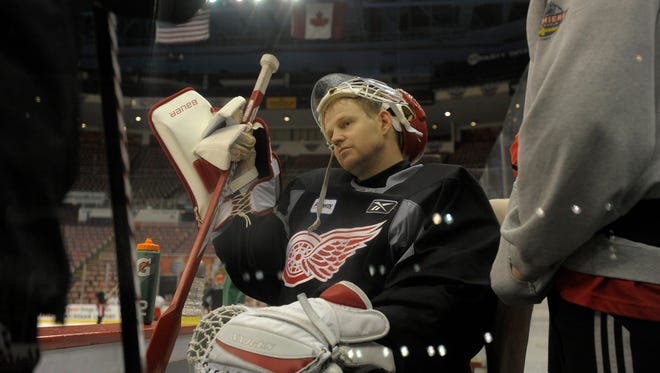 Goalie Chris Osgood takes a breather on the bench during practice at Joe Louis Arena, in Detroit, April 25, 2011.