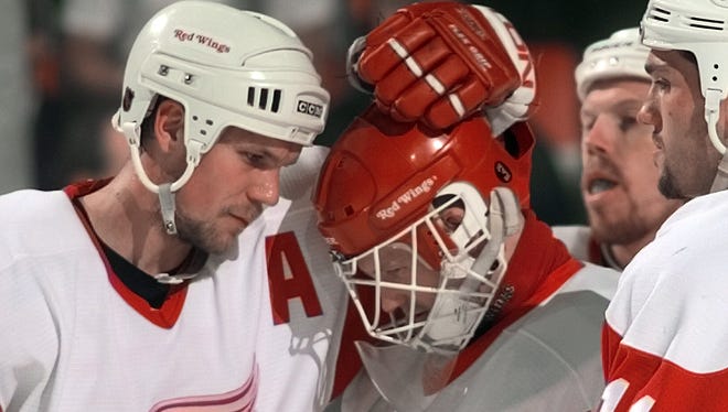 Nicklas Lidstrom, left, consoles Chris Osgood after a loss to the Colorado Avalanche, May 18, 1999, to end the season.