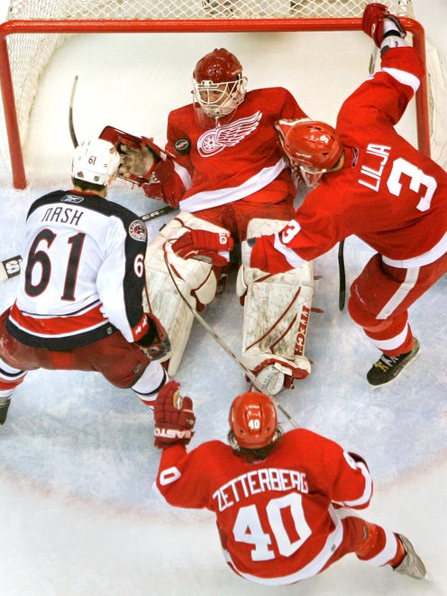 (clockwise from top) Detroit's goalie Chris Osgood, Andreas Lilja, Henrik Zetterberg, and Columbus' Rick Nash watch as Osgood makes a save in overtime during a game against the Columbus Blue Jackets at Joe Louis Arena, March 25, 2006.