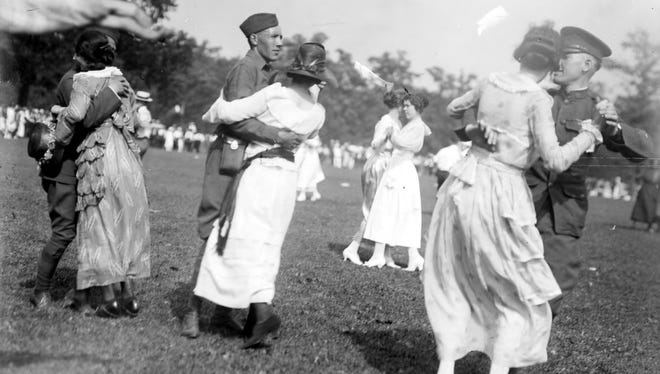 Young soldiers from Michigan's Polar Bears--the 339th Infantry that fought in Russia after the First World War--dance with women on Belle Isle during their homecoming ceremonies in July 1919.