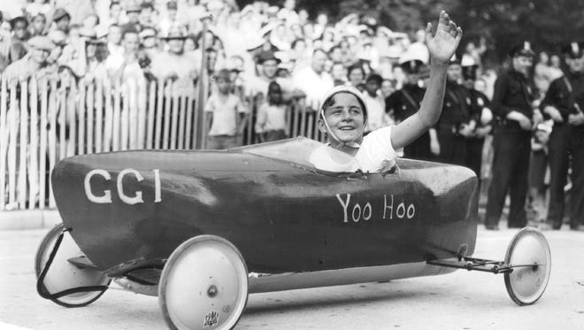 Billy White, the 1941 Detroit Soap Box champion, waves to his fans. The youth racing competition has been held in the U.S. since 1934, with a healthy presence in Metro Detroit.