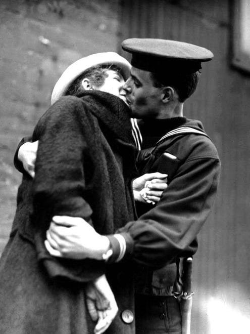 This sailor is making the most of a kiss from his sweetheart.