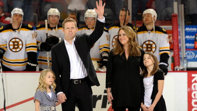 Goalie Chris Osgood, his wife Jenna, and daughters Sydney, left, and Mackenzie  take part in a ceremony honoring Osgood's 400th career win at Joe Louis Arena in Detroit, February 13, 2011.