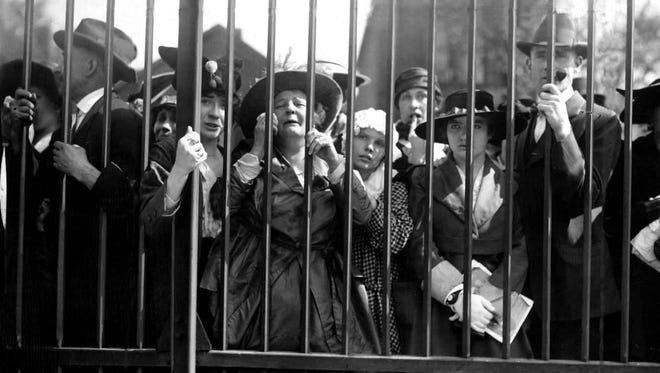 A mother cries at the train shed gates at the Michigan Central Depot in Detroit as she and others watch men head off to war.