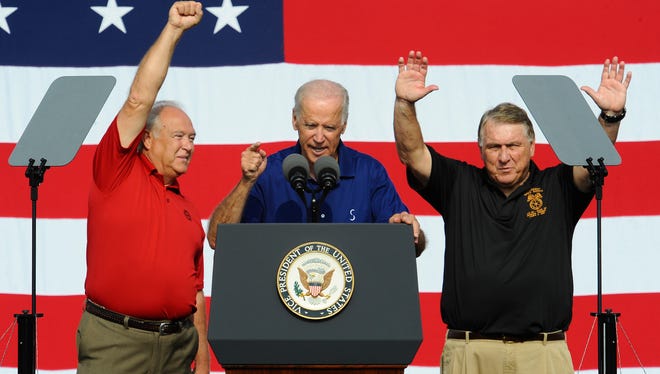 From left, UAW President Dennis Williams, United States Vice President Joe Biden and Teamsters President James Hoffa address the crowd before the start of the Labor Day Parade, at the site of old Tiger Stadium, in Detroit on Monday, Sept. 1, 2014.