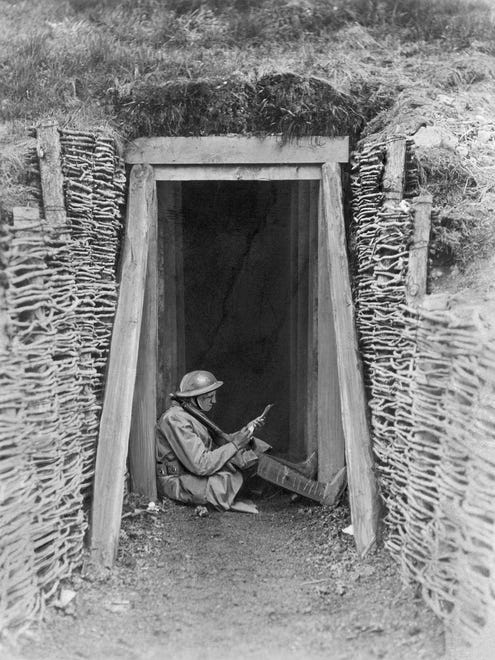 U.S. Artilleryman Fuist Dern, in the doorway of his bombproof shelter, uses a few peaceful moments to write home on March 7, 1918. The war sent millions of men into the trenches for months at a time, as what began as a temporary strategy evolved into a stalemate as neither of the opposing sides was able to gain ground.