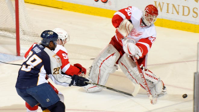 Detroit goalie Chris Osgood comes way out of the crease to keep the puck away from Nashville's Joel Ward at Joe Louis Arena,  October 30, 2010.