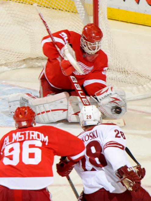 Detroit goalie Chris Osgood makes a third period stop on this play with teammate Tomas Holmstrom and Phoenix' Lauri Korpikoski at Joe Louis Arena,  October 28, 2010.