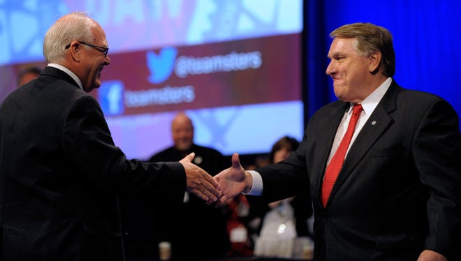 New UAW President Dennis Williams, left, shakes hands with Teamsters General President James P. Hoffa as he introduces the legendary union leader during the UAW Convention in Detroit.