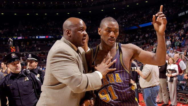Ron Artest is led off the court by Chuck Person, Pacers special consultant, after the brawl.