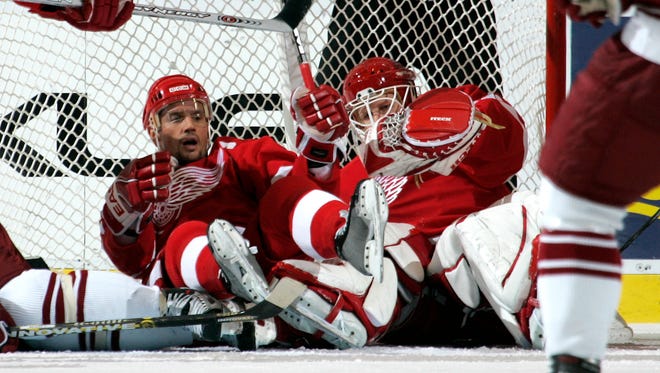 Steve Yzerman falls on top of goalie Chris Osgood during a game against the Phoenix Coyotes at Joe Louis Arena, November 5, 2005.