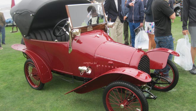 Designed by Ettore Bugatti and built under license by Peugeot, this dainty 1912 Peugeot BP1 Bebe Columbia Lamp Works Roadster, shown by George Wingard of Eugene, Ore. (with hat behind the car), was fitted with a custom body and electric lights by Columbia Lamp Works of New York City.
