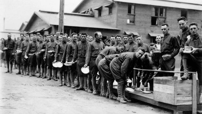 Soldiers wait in line for food.