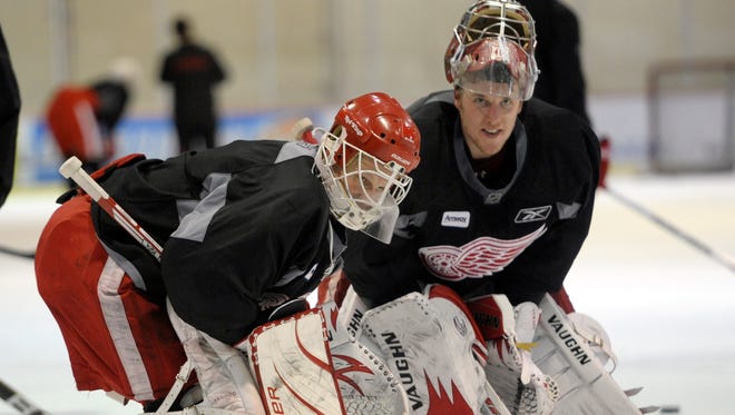 Goalies Chris Osgood, left, and Jimmy Howard take a breather during practice at the Ice Den in Scottsdale, Arizona, April 17, 2011.
