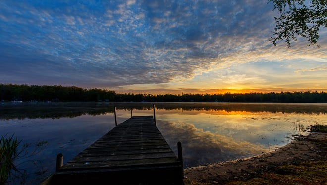 Justin Bradley of Shelby Township was relaxing early one morning at his family cottage in northern Michigan.  “As I do on any given weekend when up north, I peer outside to see if I'm going to be treated with a grand sunrise,“ he said. This was his lucky day; he grabbed his camera gear and set up at the lake to capture the cloud-filled sunrise.