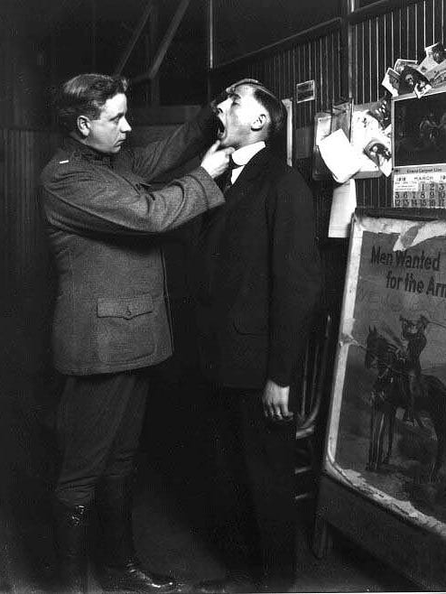 A recruit is given a medical exam, circa 1916.