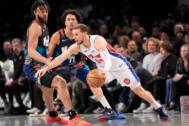 Detroit Pistons guard Malachi Flynn (14) controls the ball against Brooklyn Nets guard Lonnie Walker IV, left, and forward Jalen Wilson (22) during the first half.