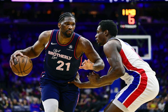 Philadelphia 76ers' Joel Embiid, left, dribbles the ball past Detroit Pistons' Jalen Duren during the first half of an NBA basketball game, Tuesday, April 9, 2024, in Philadelphia. The 76ers win, 120 to 102.