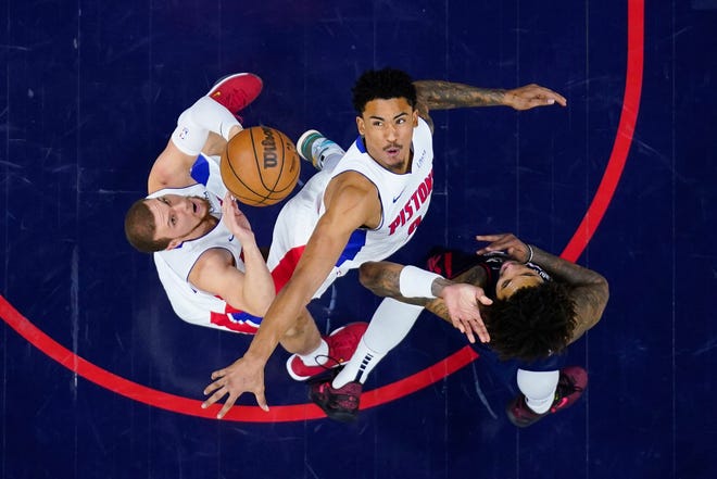 From left, Detroit Pistons' Malachi Flynn, Jared Rhoden and Philadelphia 76ers' Kelly Oubre Jr. reach for a loose ball during the second half.