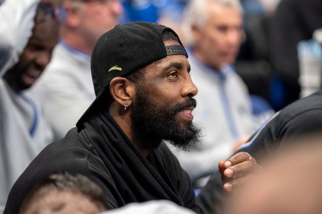 Dallas Mavericks' Kyrie Irving watches from the bench during the first half.