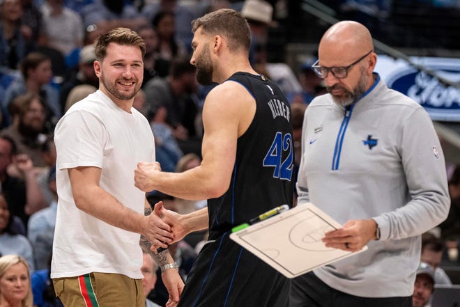 Dallas Mavericks' Luka Doncic, left, who was not playing due to ankle soreness, congratulates forward Maxi Kleber (42) as head coach Jason Kidd walks off the court during the first half.