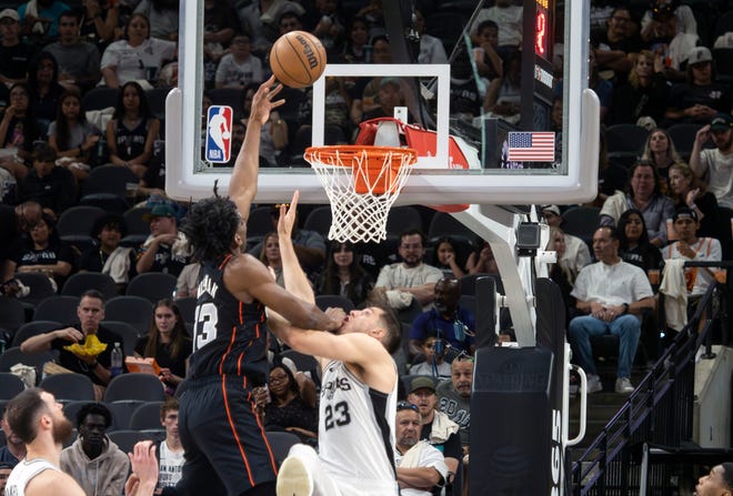 Detroit Pistons center James Wiseman, center left, shoots against San Antoinio Spurs forward Zach Collins, right, during the first half of an NBA basketball game, Sunday, April 14, 2024, in San Antonio. (AP Photo/Michael Thomas)