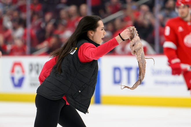 A member of the ice crew removes an octopus that was thrown onto the ice during the third period.