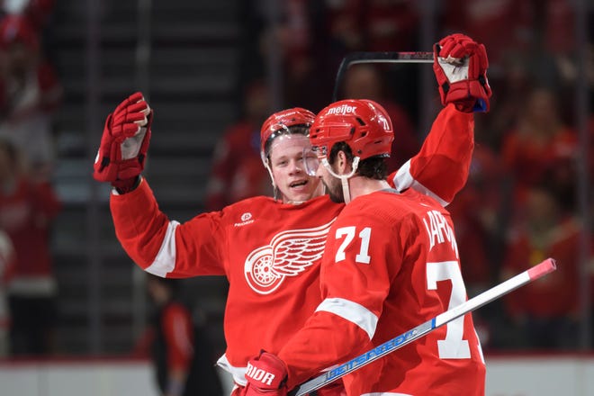Detroit left wing Lucas Raymond, left, and center Dylan Larkin celebrate after Raymond scored the game winning goal during the overtime period.
