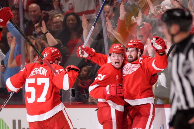 (From left) Detroit left wing David Perron, left wing Lucas Raymond, and center Dylan Larkin celebrate after Raymond scored the game winning goal during the overtime period of a game between the Detroit Red Wings and the Montreal Canadiens at Little Caesars Arena, in Detroit, April 15, 2024.