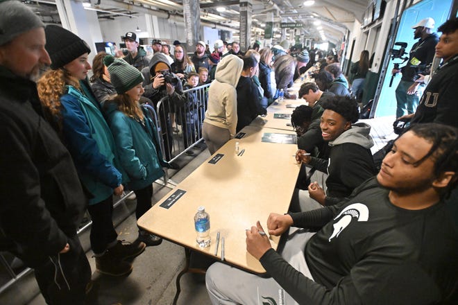 Michigan State offensive lineman Brandon Baldwin and quarterback Aidan Chiles sign autographs for fans before the Michigan State football's spring showcase/scrimmage at Spartan Stadium.