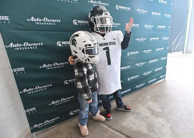 Looking like they are in midseason form, Olivia and Joseph Smith try on Spartan football gear before the Michigan State football's spring showcase/scrimmage at Spartan Stadium.