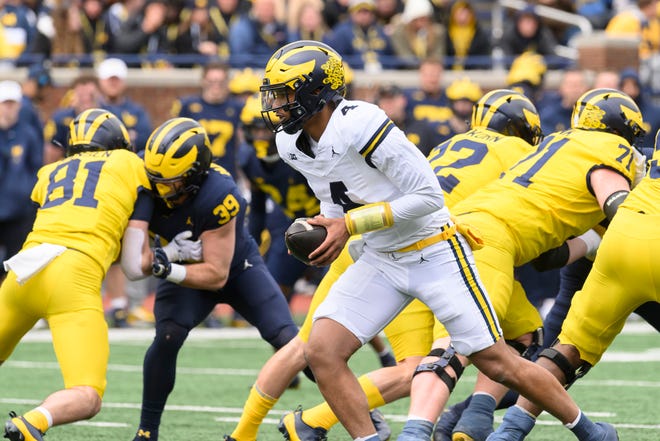 Team Maize quarterback Jayden Denegal looks to hand off the ball in the third quarter of the annual spring game at Michigan Stadium.